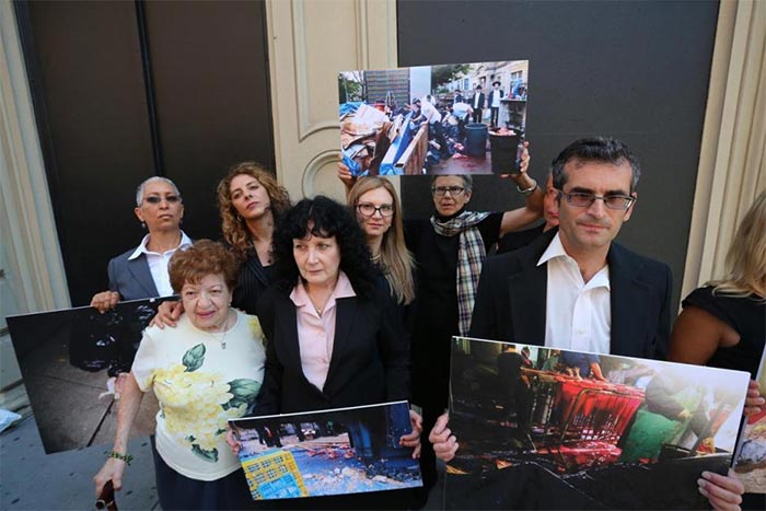 Members of The Alliance to End Chickens as Kaporos pose with photo exhibits outside 71 Thomas St. on Tuesday in New York. The group of Brooklyn residents is suing four rabbis, several Hasidic congregations and the city to stop an annual religious ritual that involves chicken flying and slicing chickens' necks on the sidewalk.